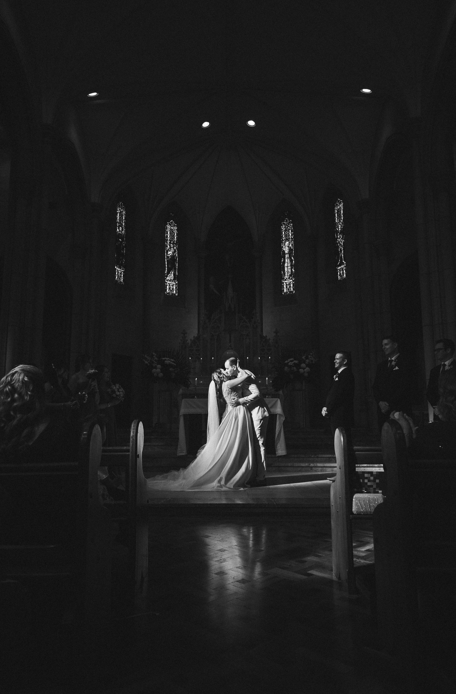 amazing capture of a church kiss with divine lighting at the right time